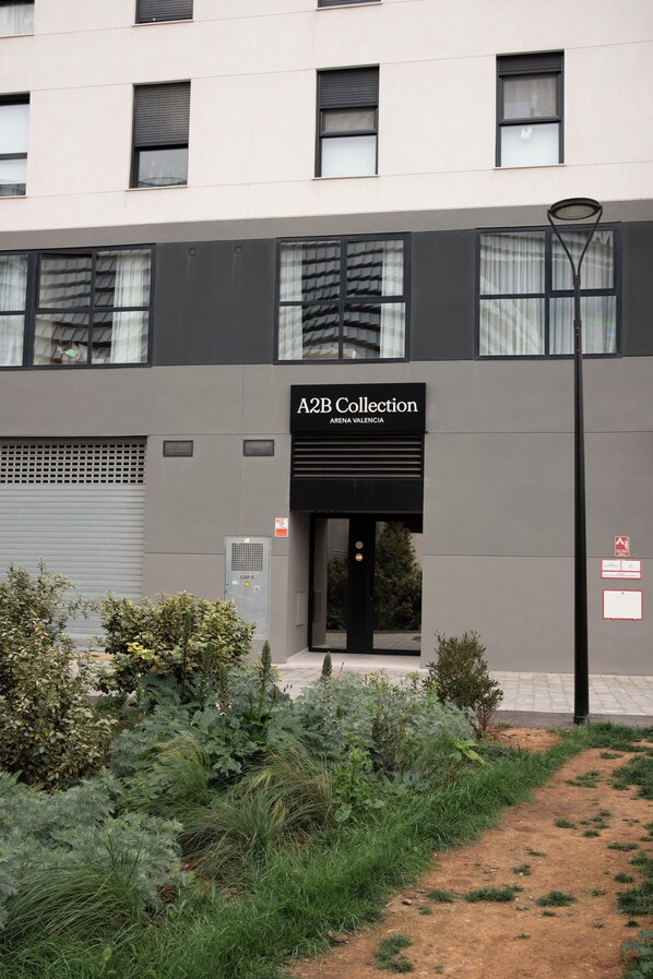 Um edifício moderno com uma placa indicando 'A2B Collection' e uma entrada coberta.