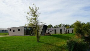 A modern building with a flat roof, large windows, and a grassy courtyard. - Holiday Home in Kampen With Terrace (Kampen)