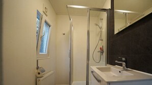 Une salle de bain moderne équipée d’une douche, d’un lavabo et de toilettes.