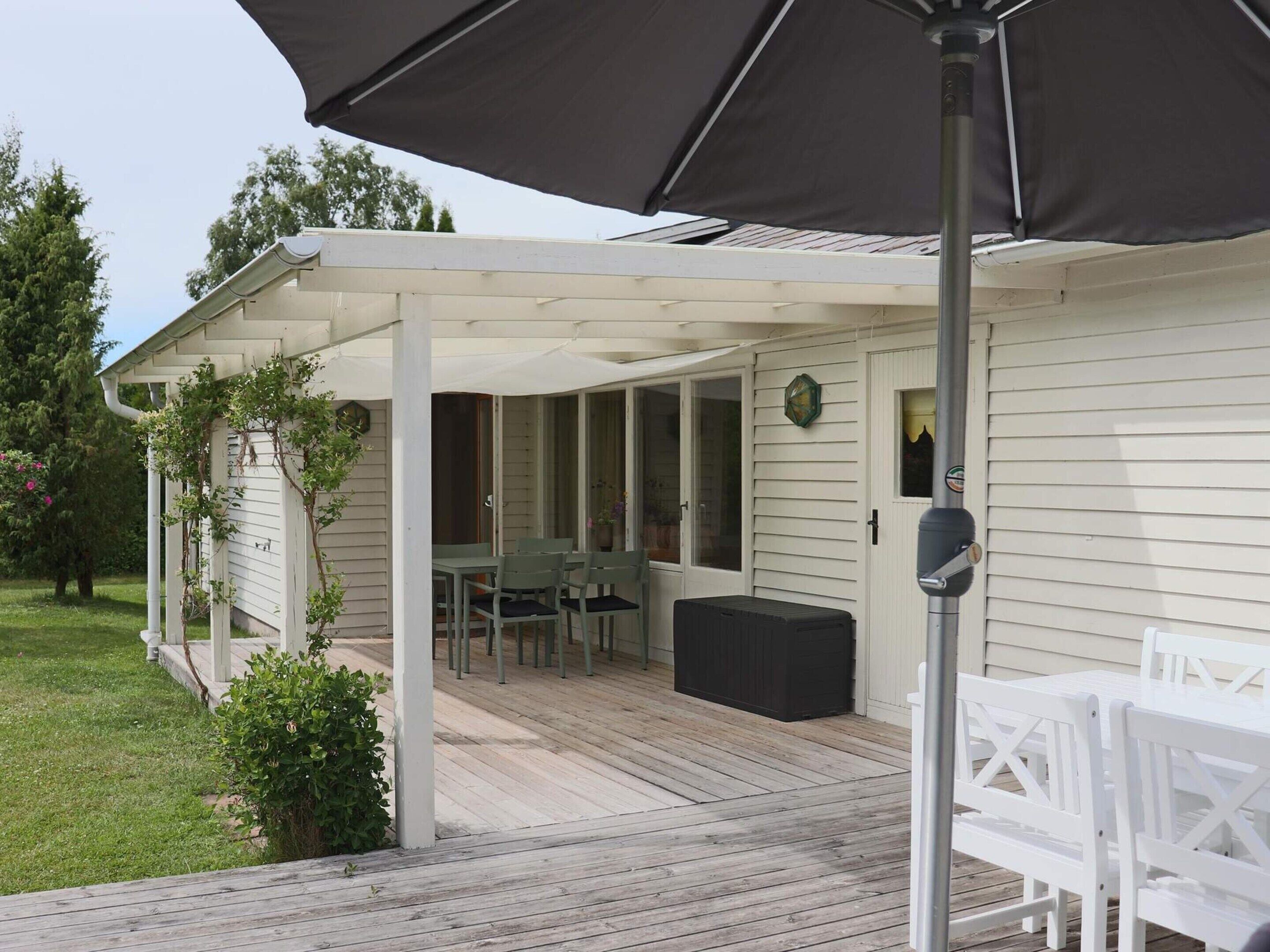 A covered patio with outdoor furniture, a clock, and a mailbox.