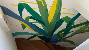 A staircase with a wall mural of a plant.