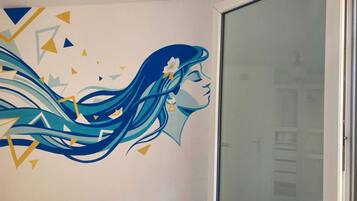 Un mur orné d’une fresque représentant le profil d’une femme et de lignes fluides.