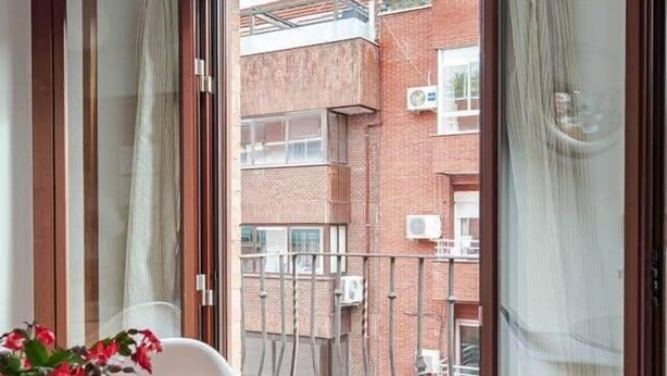 A balcony with a glass table, white chairs, and a potted plant. - Apartment. Balcony, bright, centrally located (Madrid)