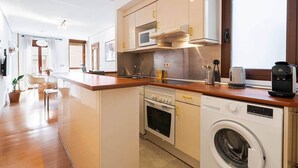A compact kitchen with a built-in oven, microwave, and washing machine. - Apartment. Balcony, bright, centrally located (Madrid)
