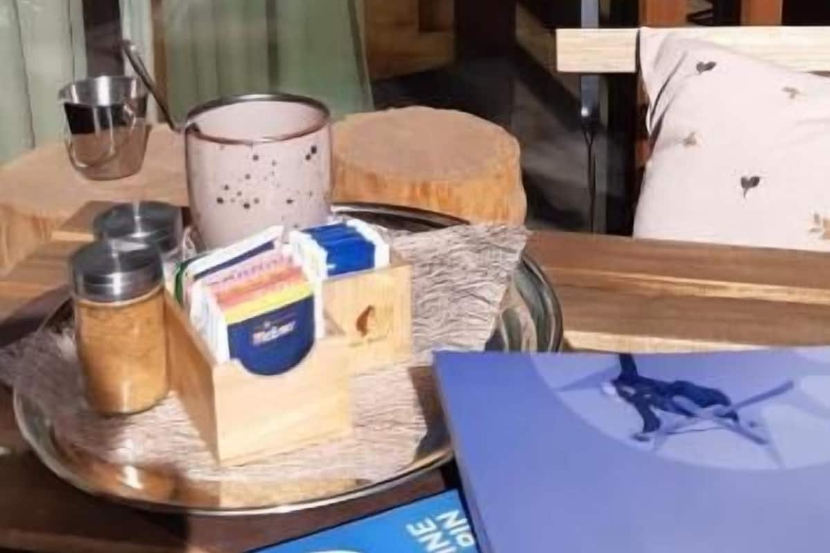 A table with a tray containing a mug, a box of tissues, and a small container.