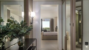 Habitació d'hotel amb un llit, una taula de nit, un mirall i una planta en test.