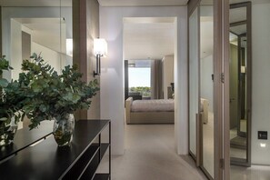 A hotel room with a bed, a bedside table, a mirror, and a potted plant. - Halcyon Villa (Cape Town)