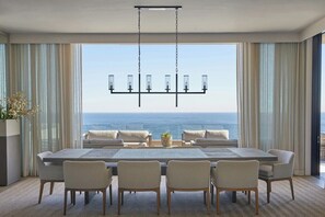 A dining area with a view of the ocean, a chandelier, and a table set for six. - Halcyon Villa (Cape Town)
