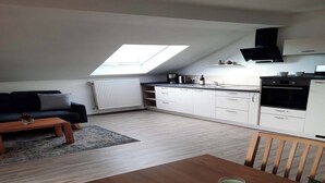 A modern apartment with a loft-style kitchen, a dining area, and a living room. - Vacation rental, 45 square meters, 2nd floor, 1 separate bedroom (Bad Endorf)