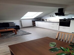 A modern apartment with a loft-style kitchen, a dining area, and a living room. - Vacation rental, 45 square meters, 2nd floor, 1 separate bedroom (Bad Endorf)
