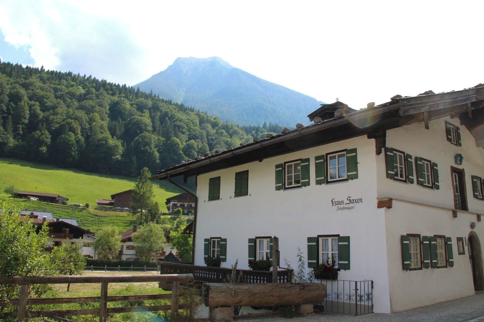 A traditional building with a sign reading 'Haus Saxen' in a rural setting with a mountain in the background.