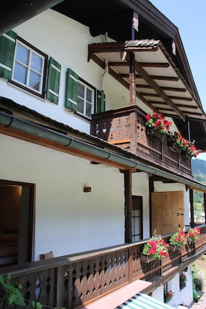 A traditional chalet with a balcony, wooden railings, and flower boxes. - Steinberg Vacation Rental (Ramsau bei Berchtesgaden)
