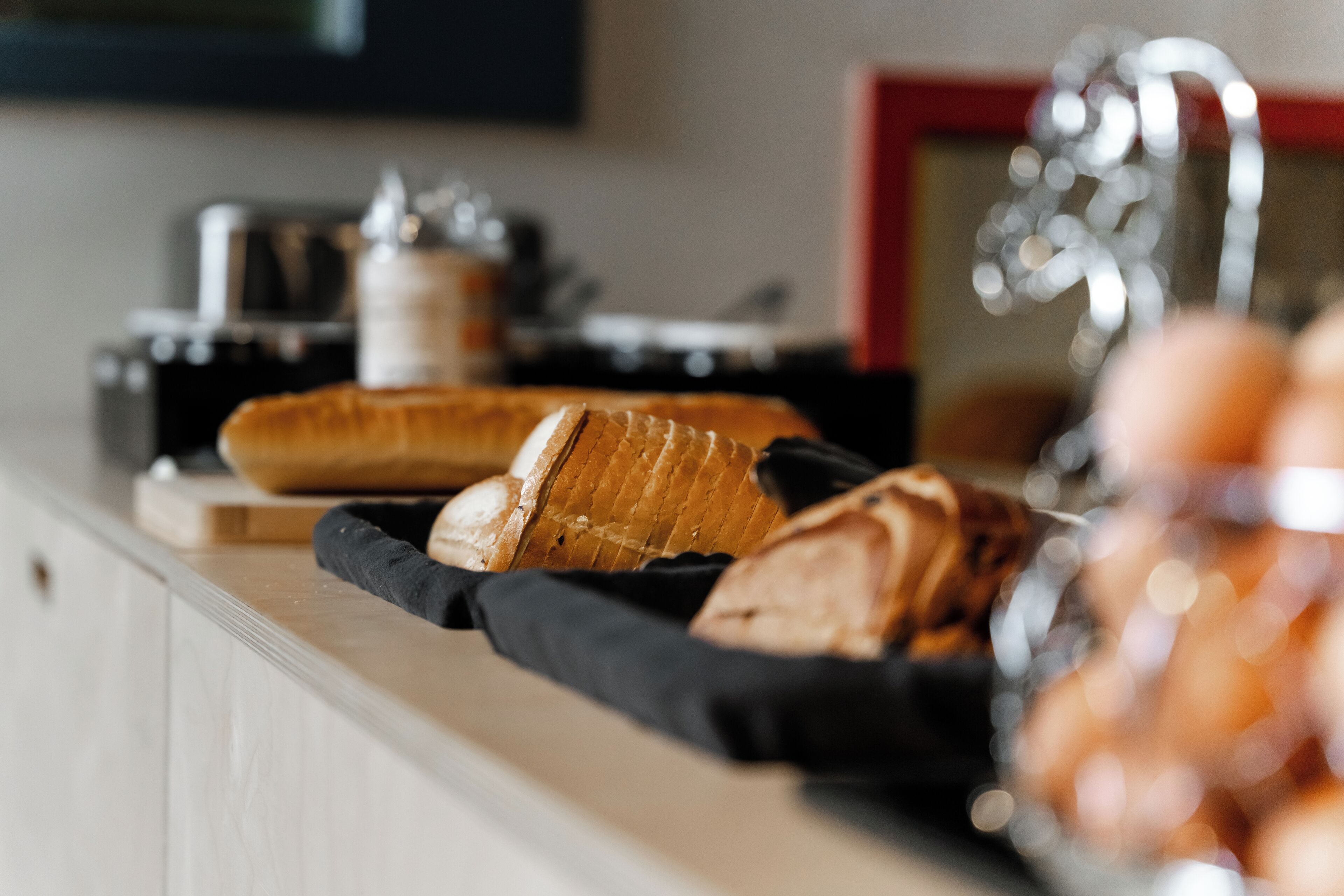 A kitchen counter with bread and a kettle.