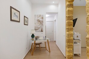A hallway with a glass table, framed pictures, and a textured wall. - Room 'Ferrovia' with Balcony, Wi-Fi and Air Conditioning (Palermo)