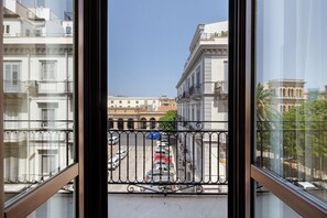 A view from a balcony with a railing, overlooking a street with parked cars and buildings in the background. - Room 'Stazione' with Balcony, Wi-Fi and Air Conditioning (Palermo)