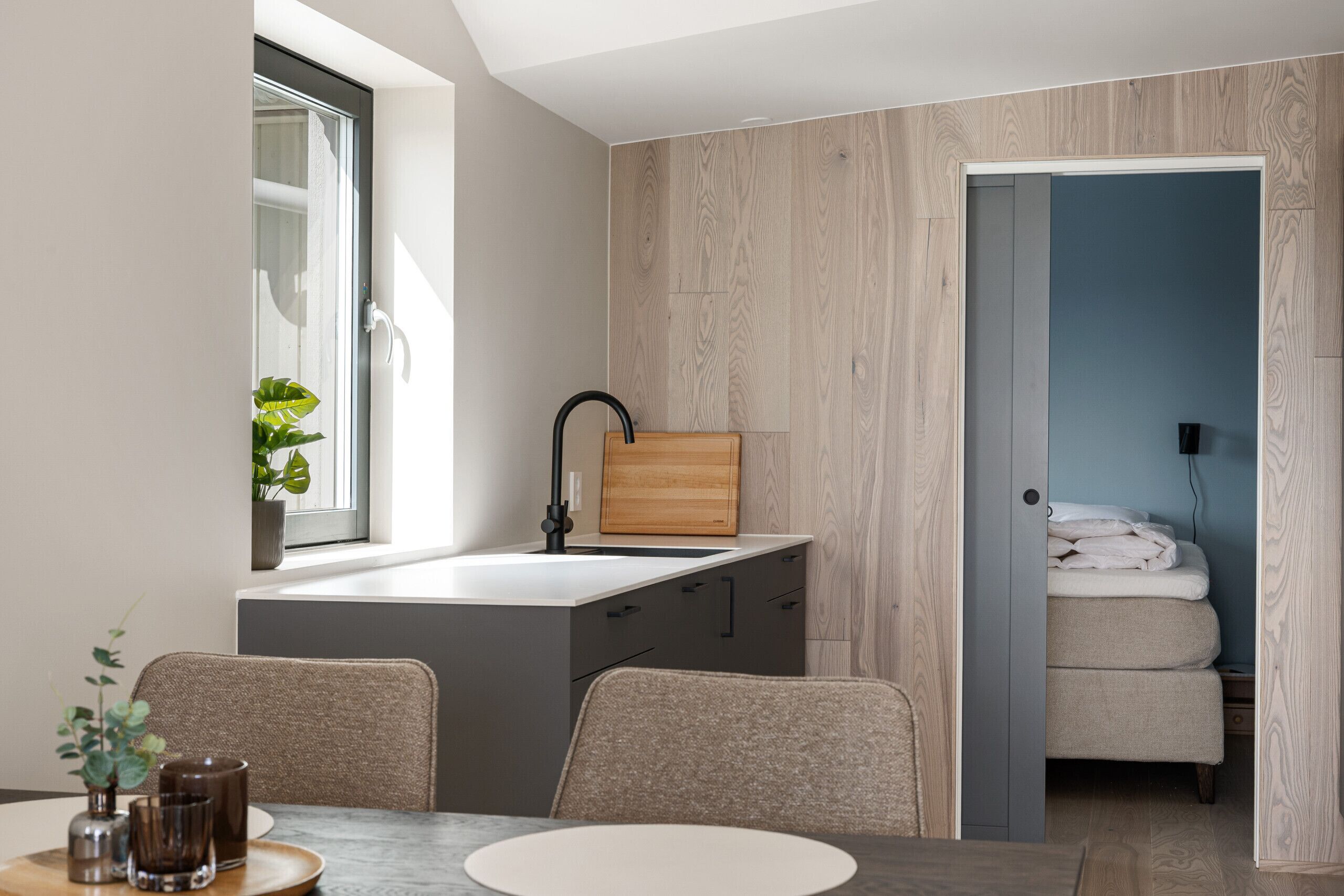 Une cuisine moderne avec une fenêtre, un évier et une planche à découper en bois.