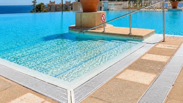 A clear blue pool with a no diving sign, surrounded by palm trees and a building with a white facade in the background. - Panoramic sea view • Swimming pool • Terrace • Tennis court • Parking • Cannes (Cannes)