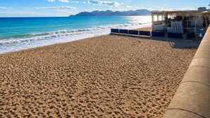 A beach with a lifeguard station, clear blue sky, and ocean waves. - Panoramic sea view • Swimming pool • Terrace • Tennis court • Parking • Cannes (Cannes)