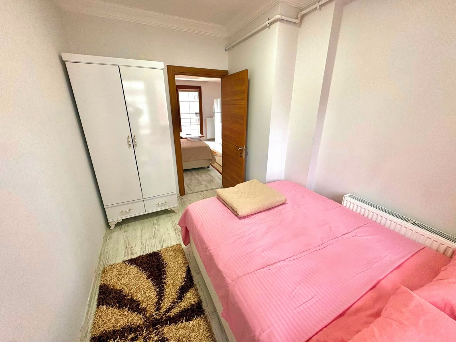Ein Schlafzimmer mit einem Bett, einem Kleiderschrank und einer Heizung.