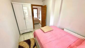 Ein Schlafzimmer mit einem Bett, einem Kleiderschrank und einer Heizung.