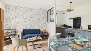 Un salon moderne avec un canapé, une table basse et un coin repas comprenant des chaises et de l’assiette.