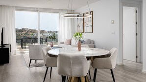 A modern dining area with a round table, chairs, and a view of the outdoors. - Casa Banderas Sea & Valley Views by Alfresco Stays (Mijas)