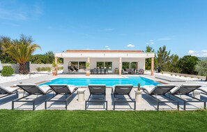 A modern house with a swimming pool, outdoor seating, and a covered patio. - Stunning home in Pridraga (Pridraga)