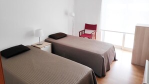 A room with two beds, a chair, a desk, and a window. - House with a private pool, Caminha (Viana do Castelo)