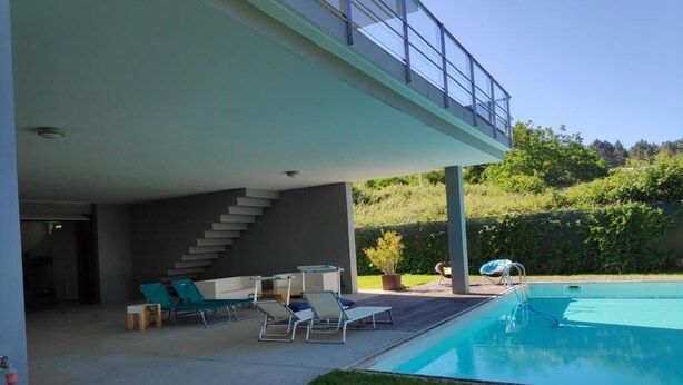 A modern house with a swimming pool, outdoor seating, and a staircase leading to an upper level. - House with a private pool, Caminha (Viana do Castelo)