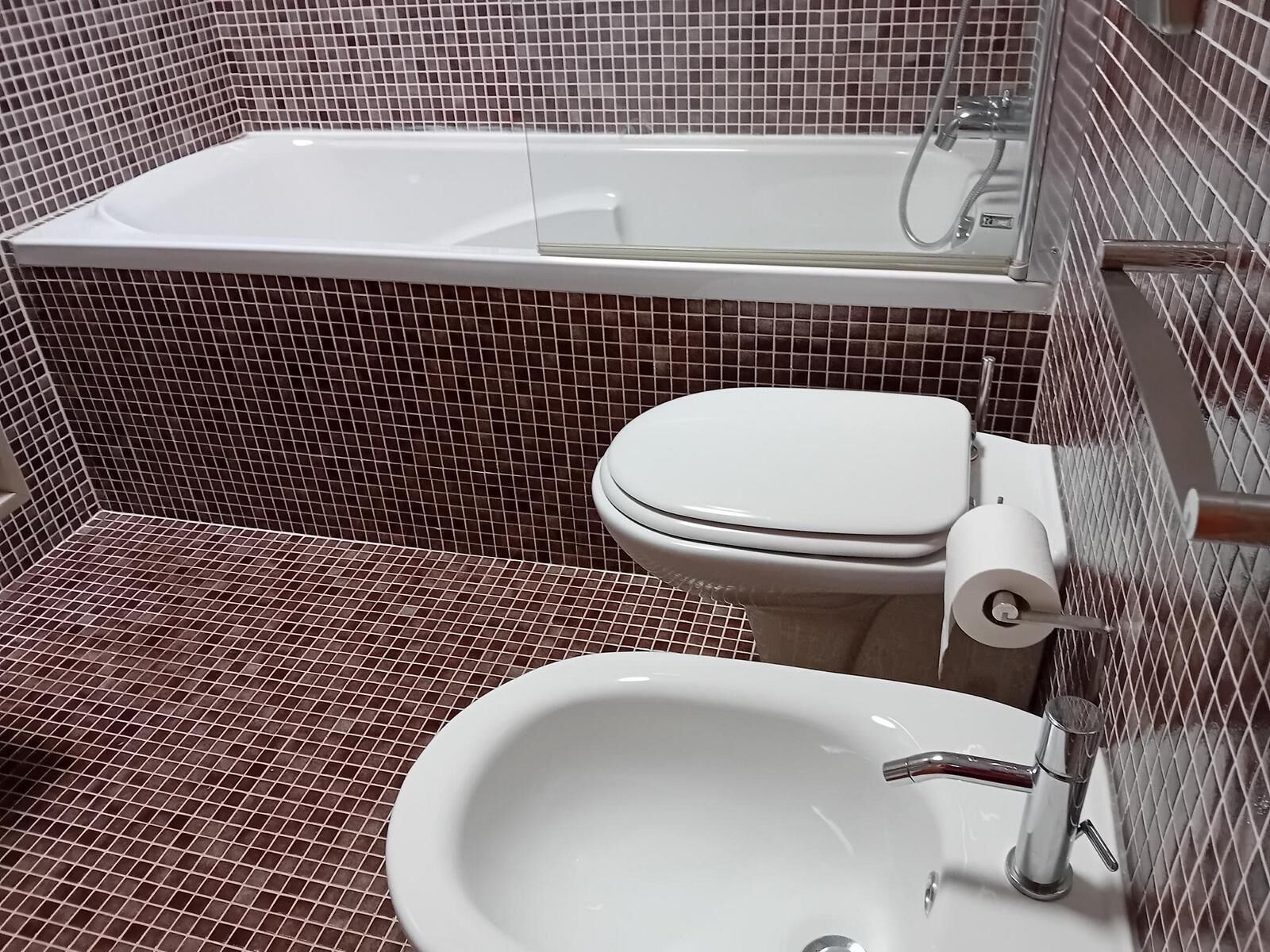 A bathroom with a white bathtub, toilet, and sink.