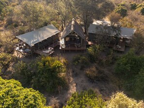 A lodge with multiple cabins, outdoor seating, and surrounded by dense vegetation. - Thitaka River Lodge by NEWMARK - All Inclusive (Kongola)