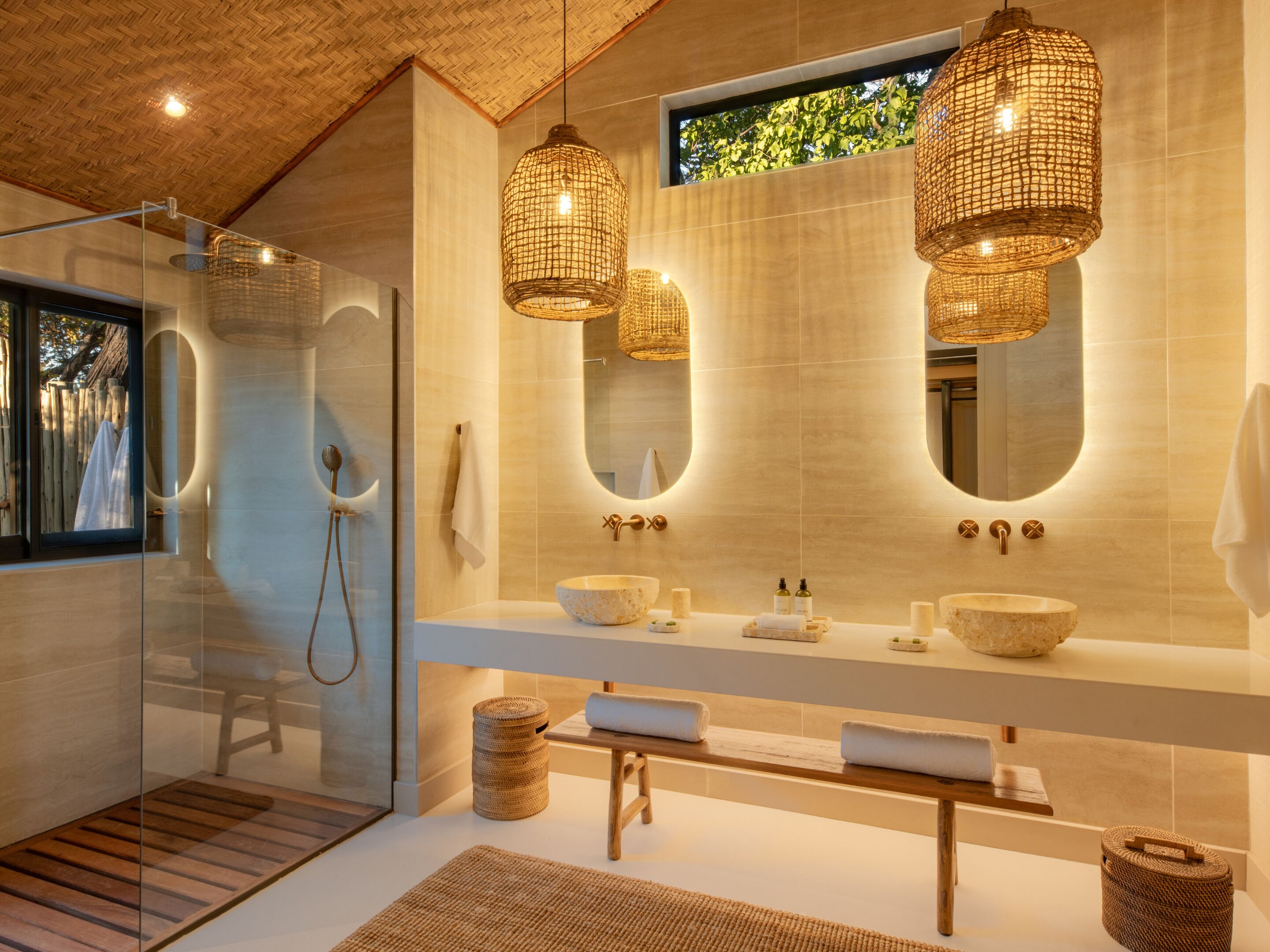 Ein modernes Badezimmer mit einer Duschkabine aus Glas, einem geräumigen Waschtisch mit zwei Becken und einem großen Spiegel.