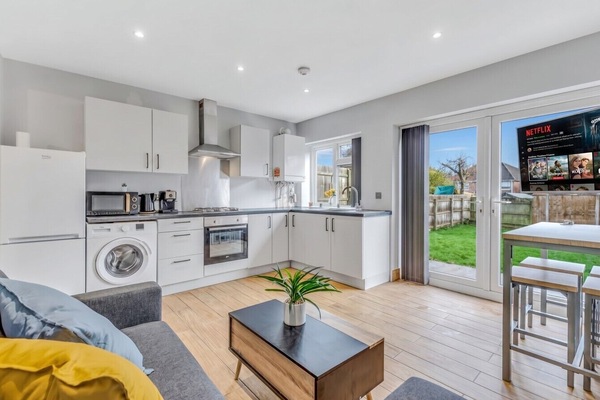 Bright open kitchen and lounge with Netflix smart TV and garden doors