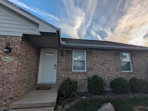 A two-story brick house with a white front door, a mailbox, and a number '2622' on the wall. - Main Stays West - Half Duplex (Troy)