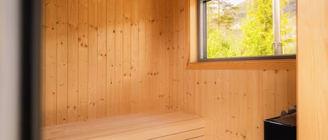 A sauna room with wooden walls and a bench.