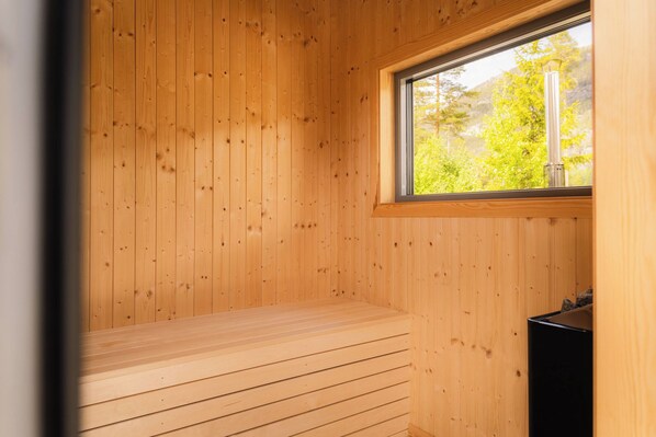 A sauna room with wooden walls and a bench.