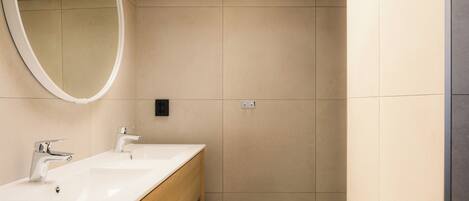 A bathroom with two sinks, a mirror, and wooden cabinetry.