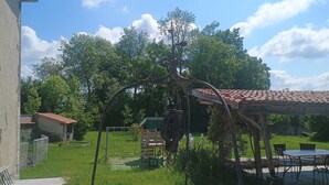 En trädgård med en pergola, en gunga och en matplats med utemöbler.