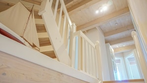 A wooden staircase with white railings and a wooden floor. - Warftkroog Thatched-Roof House: Thatched-roof house for 20 people with a sauna and hot tub (Katharinenheerd)