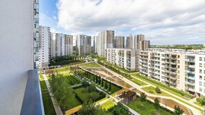 Un ensemble immobilier résidentiel composé d’immeubles à étages, d’espaces verts et offrant une vue dégagée sur le ciel.