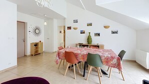Ein Essbereich mit einem Tisch für vier Personen, umgeben von Stühlen.
