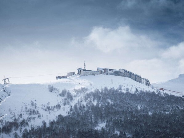 Un monte cubierto de nieve con un conjunto de edificios en una colina.