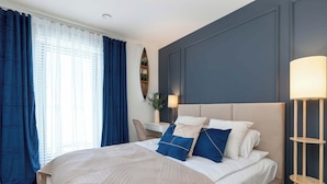 A bedroom with a bed, a desk, a chair, and a lamp. - Luxury Apartment with a Balcony | Balcony (Władysławowo)