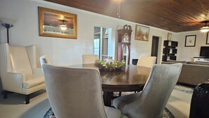 Un coin repas avec un plafond en bois, une table ronde et quatre chaises.