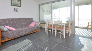 Een woonkamer met een bank, stoelen, een tafel en een balkon met uitzicht.