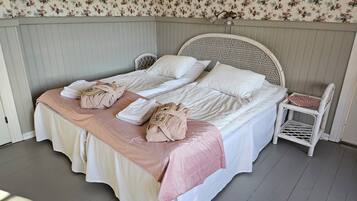 Un lit avec deux oreillers, une table de chevet et une chaise.