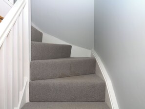 A staircase with carpeted steps and white railings. - Fieldstone Barn (Okehampton)