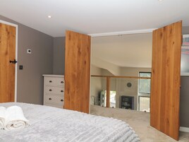 Um quarto com uma cama, uma cômoda e uma porta de correr que dá para uma varanda.