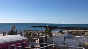 Una zona costera con cielo despejado, un faro y una playa.