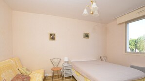 Une chambre à coucher avec un lit, un canapé, une petite table et une chaise.